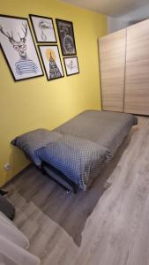a bed in a room with pictures on the wall at Apartament na Moniuszki in Legnica