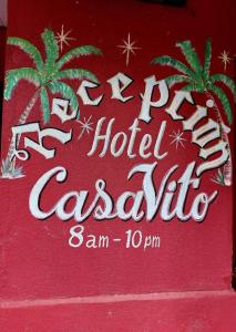 a red sign for a hotel casino with two palm trees at Hotel Casa Vito Beachfront in Puerto Viejo