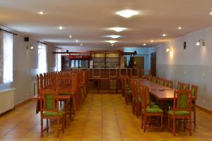 a dining room with a long table and chairs at Penzion U parku in Rumburk