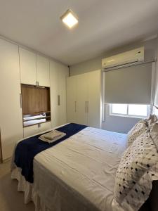 a bedroom with a large white bed and a window at Flat em Brasília - Moderno e equipado in Brasilia