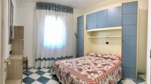 een slaapkamer met een bed en een raam bij Condominio Ca Brioni in Bibione