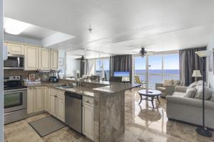 a kitchen and living room with a view of the ocean at Beach Front 18th Flr, Best Ocean View, New Upgrades in Destin