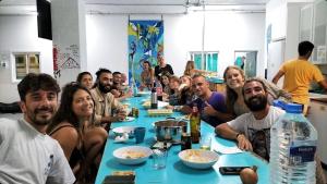 a group of people sitting at a long table at Medano Nest Hostel in El Médano