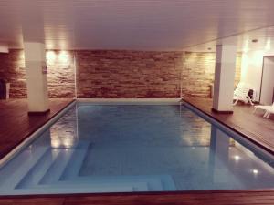 una gran piscina en una habitación con una pared de ladrillo en Golden Beach Resort & Spa en Punta del Este