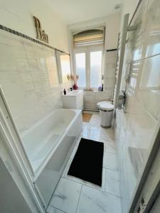 Duża biała łazienka z wanną i toaletą w obiekcie Duplex 100m2, 3 Chambres, Centre, Garage w mieście Valenciennes