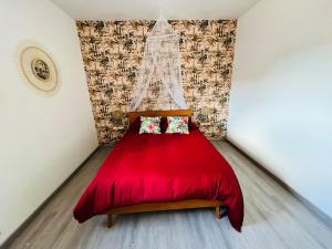 czerwone łóżko z zasłoną i dwoma poduszkami w obiekcie 1 Duplex 100m2, 3 Chambres, Centre, Garage w mieście Valenciennes