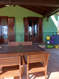 un tavolo in legno e 2 panche su un patio di Etna Green House a Zafferana Etnea
