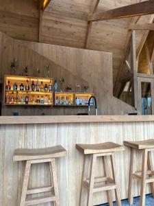 a bar with two wooden stools and a counter at Tawa Refugio del Puelo in Puelo