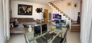 een woonkamer met een glazen tafel en een trap bij Appartamento Borgo Secolo in Peschiera del Garda