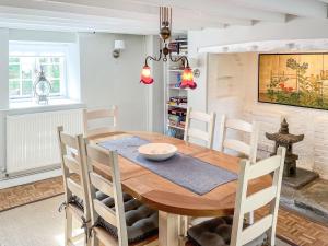 - une salle à manger avec une table et des chaises en bois dans l'établissement Cuckoo Nod Cottage, à Wool