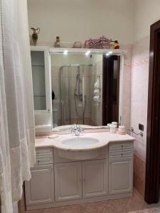 y baño con lavabo, ducha y espejo. en La Casa di Margot en Forte dei Marmi