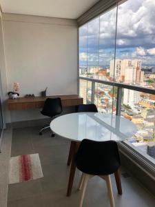 una oficina con mesa, sillas y una ventana grande en Monte Fuji ~ GRU 39m2, en Guarulhos