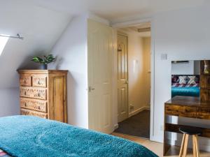 een slaapkamer met een blauw bed en een houten dressoir bij Hobbit House in Horncliffe