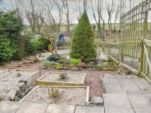 een tuin met twee verhoogde bedden en een hek bij Hobbit House in Horncliffe