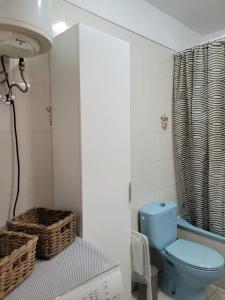 uma casa de banho com um WC azul e um lavatório. em Muy Seguro - Great view for Playa de la Arena em Puerto de Santiago