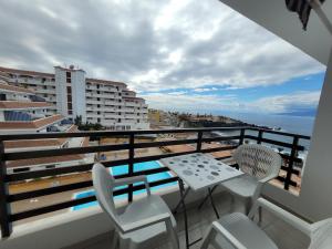 uma varanda com mesa e cadeiras e vista para o oceano em Muy Seguro - Great view for Playa de la Arena em Puerto de Santiago