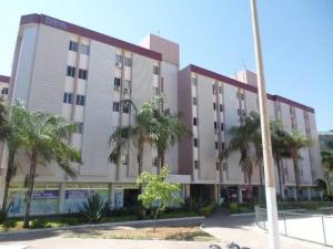 a large building with palm trees in front of it at Flat em Brasília - Moderno e equipado in Brasilia