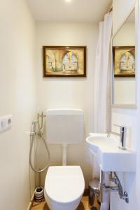 a bathroom with a white toilet and a sink at Villa d exception avec terrasse, jacuzzi, vue mer, parking, en plein cœur du village de Eze in Èze