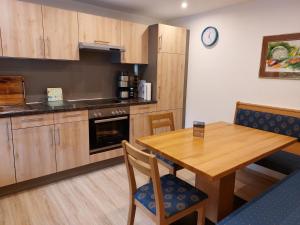 a kitchen with a wooden table and a dining room at Ferienwohnungen Haus Moser in Berchtesgaden