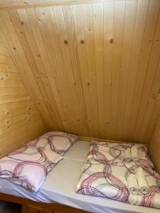 a bed in a room with a wooden ceiling at Perníková chalúpka 