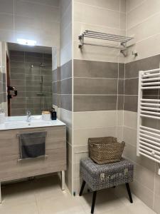 baño con lavabo, espejo y silla en Appartement d'exception - Vue panoramique sur lac, en Évian-les-Bains 9 fotos más