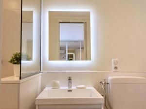 a white bathroom with a sink and a mirror at Villa d exception avec terrasse, jacuzzi, vue mer, parking, en plein cœur du village de Eze in Éze