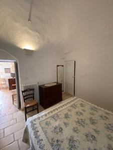 1 dormitorio con cama, tocador y espejo en Trullo Fiorino, en Cisternino
