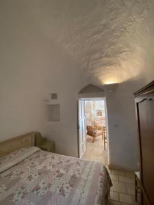1 dormitorio con 1 cama y puerta que da a un patio en Trullo Fiorino, en Cisternino
