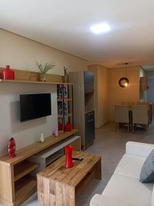 a living room with a television and a table at ARCO IRIS KITNETS in Fortaleza