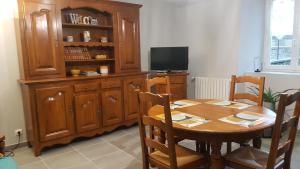 een eetkamer met een houten tafel en een televisie bij Maison de Romagers in Aumont-Aubrac