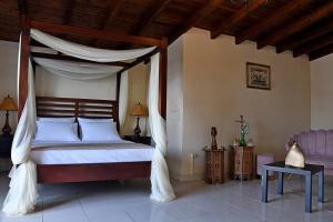 um quarto com uma cama de dossel e um sofá em Villa Gray em Ixia