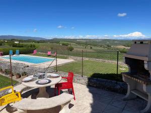 a patio with a table and chairs and a pool at La Ferme l'Etang in Vachères