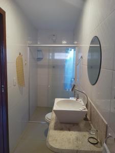uma casa de banho branca com um lavatório e um WC em Pousada Mar Mai em Pipa