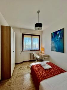 ミラノにあるGreen Guest Houseのベッド、デスク、窓が備わるホテルルームです。