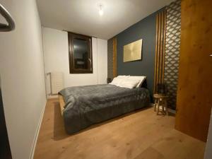 ein Schlafzimmer mit einem Bett und einem Holzboden in der Unterkunft O'Léman avec Sauna inclus in Thonon-les-Bains