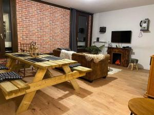 ein Wohnzimmer mit einem Holztisch und einem Kamin in der Unterkunft O'Léman avec Sauna inclus in Thonon-les-Bains