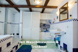 a bathroom with a sink and a shower and a toilet at Ferienhaus Schwarzwald bei Straßburg Europapark für 12 Personen auf 160qm in Rheinau +33 photos