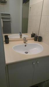 ein Badezimmer mit einem weißen Waschbecken und einem Spiegel in der Unterkunft Loudenvielle résidence l'Orée des Monts in Loudenvielle