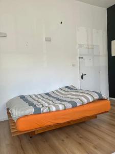 a bed with an orange frame in a room at Bright Studio in Shapira in Tel Aviv