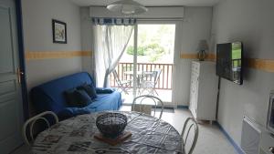 ein Wohnzimmer mit einem Tisch und einem blauen Sofa in der Unterkunft Loudenvielle résidence l'Orée des Monts in Loudenvielle
