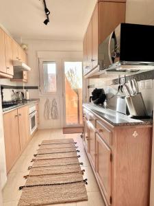 una cocina con armarios de madera y una alfombra en el suelo en Newly Refurbished Apartment, en Cuevas del Almanzora
