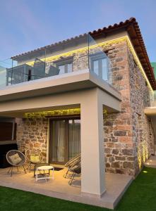 a stone house with a patio and a balcony at Piedra Luxury Apartments in Nafplio