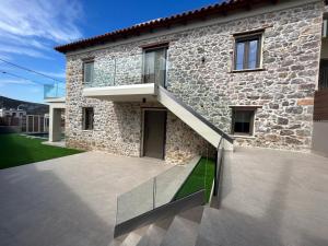 a stone house with a staircase in front of it at Piedra Luxury Apartments in Nafplio