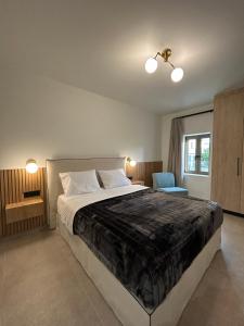 a bedroom with a large bed and a blue chair at Piedra Luxury Apartments in Nafplio