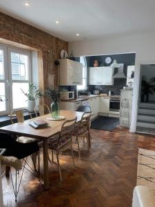 uma cozinha com uma mesa de madeira e cadeiras em Beautiful Townhouse with Parking Sleeps 6 em Kingsbridge