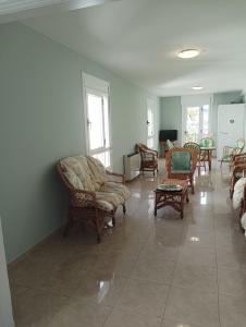 una sala de estar con sillas y mesas en un suelo de baldosa. en Hotel Villa Jardín, en Portomarín