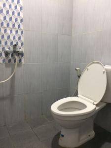 a bathroom with a white toilet in a room at Omah Ndanu Homestay in Yogyakarta