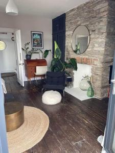 a living room with a chair and a mirror at Beautiful Townhouse with Parking Sleeps 6 in Kingsbridge