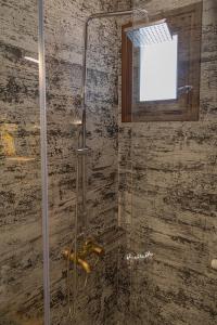 y baño con ducha y puerta de cristal. en Stefanis Guest House, en Krásion