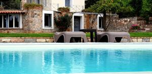 two tables and chairs next to a swimming pool at Private Swimmingpool in Cottage in Poros